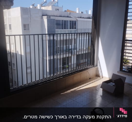 מעקה מתכת במרפסת עם קופסה פתוחה על הרצפה